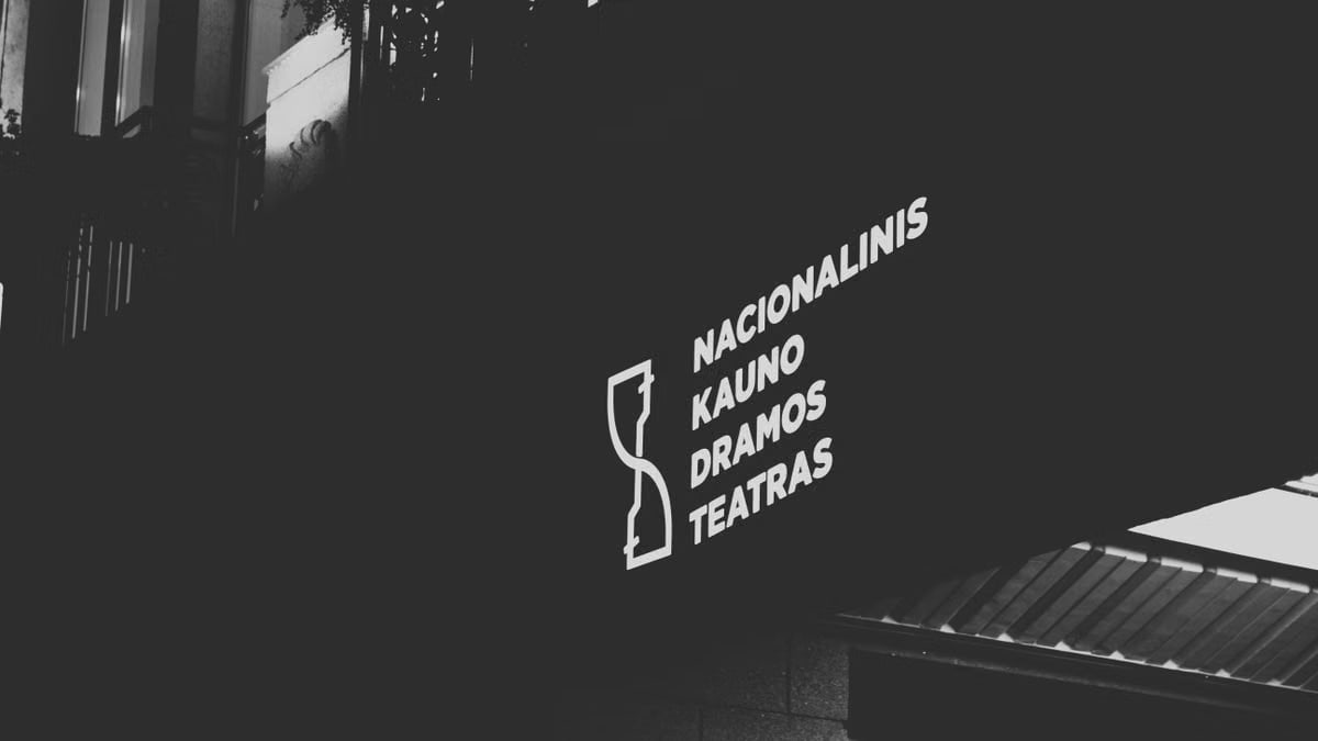 Illuminated signage of Kaunas Drama Theatre in black and white low angle shot.